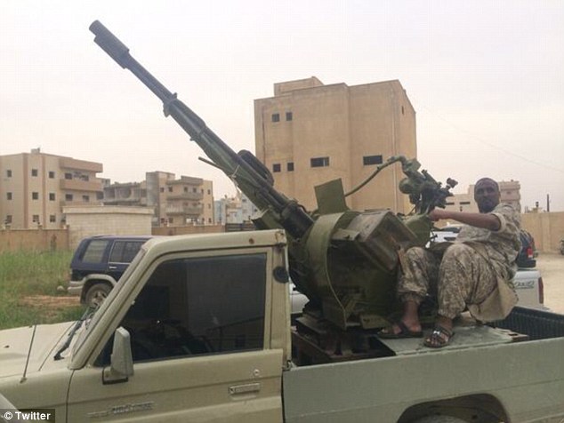 Ready for war: Taymullah al-Somali is seen posing with an anti-aircraft gun while dressed in combat fatigues