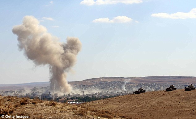 'Terrorism': A photograph taken from Turkey on Thursday shows smoke rising following U.S.-led airstrikes in Kobani, Syria. Zubayr says the attacks will cause militants to react and attack the U.S.