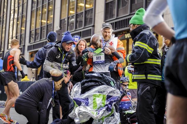 Mo Farah (center)  is helped into a wheelchair after collapsing at the finish line of the NYC Half-Marathon Sunday.