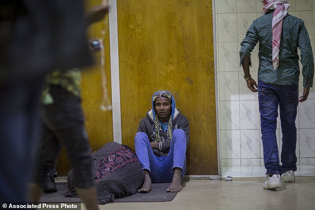 In this photo taken Friday, Dec. 22, 2017, Sabit Mohammed, 18, sits in a corridor after being deported barefoot from Saudi Arabia, at the airport in Addis Ababa, Ethiopia. Undocumented Ethiopian migrants who are being forcibly deported from Saudi Arabia by the thousands in a new crackdown say they were mistreated by authorities while detained. (AP Photo/Mulugeta Ayene)