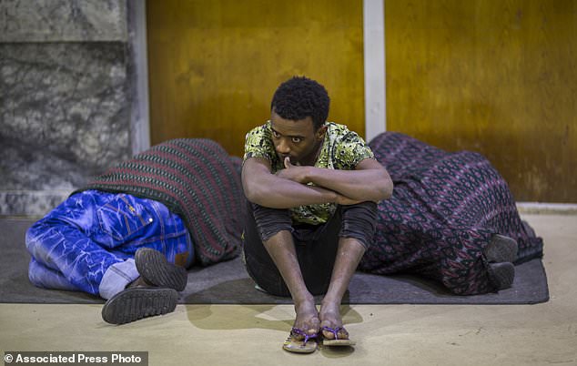 In this photo taken Friday, Dec. 22, 2017, Ethiopian Zeynu Abebe, 19, sits in between two others upon his arrival after being deported from Saudi Arabia, at the airport in Addis Ababa, Ethiopia. Undocumented Ethiopian migrants who are being forcibly deported from Saudi Arabia by the thousands in a new crackdown say they were mistreated by authorities while detained. (AP Photo/Mulugeta Ayene)