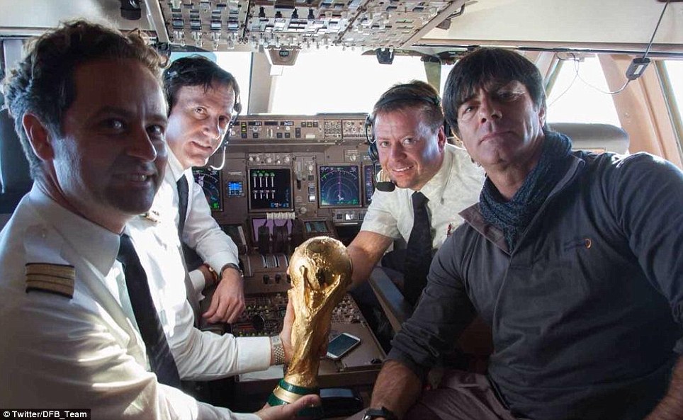 Looking good, Jogi! Low takes a spot in the cockpit of the delayed flight from Rio di Janeiro with pilots, the captain and World Cup trophy