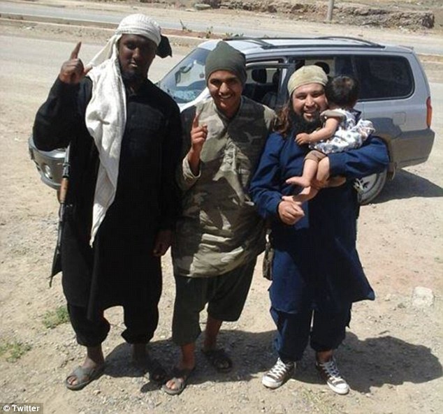 Chilling: This photograph shows al-Somali among a group of gun-toting militants holding a young child in Syria
