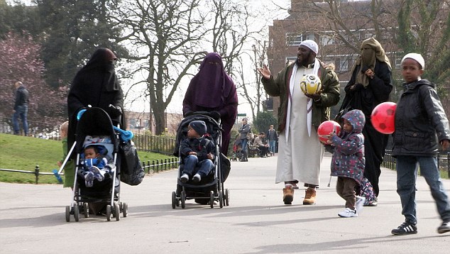 Hasan Phillips takes a stroll in the park with his three wives and children - there are an estimated 20,000 polygamous marriages taking place in Britain 