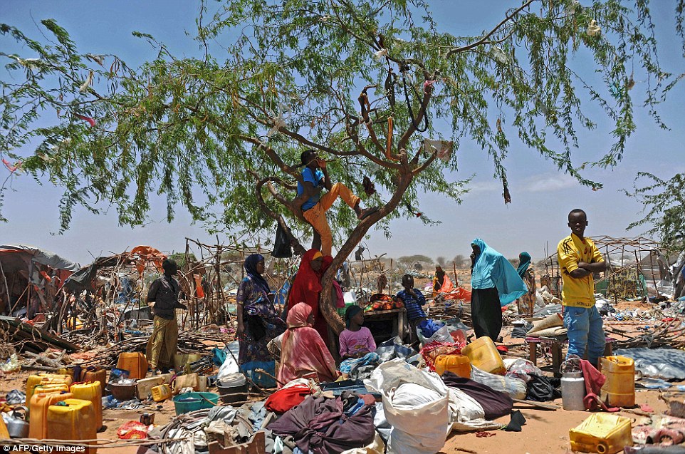 Uncertain: These refugees have been left wondering what to do next and are pictured standing among their scattered possessions