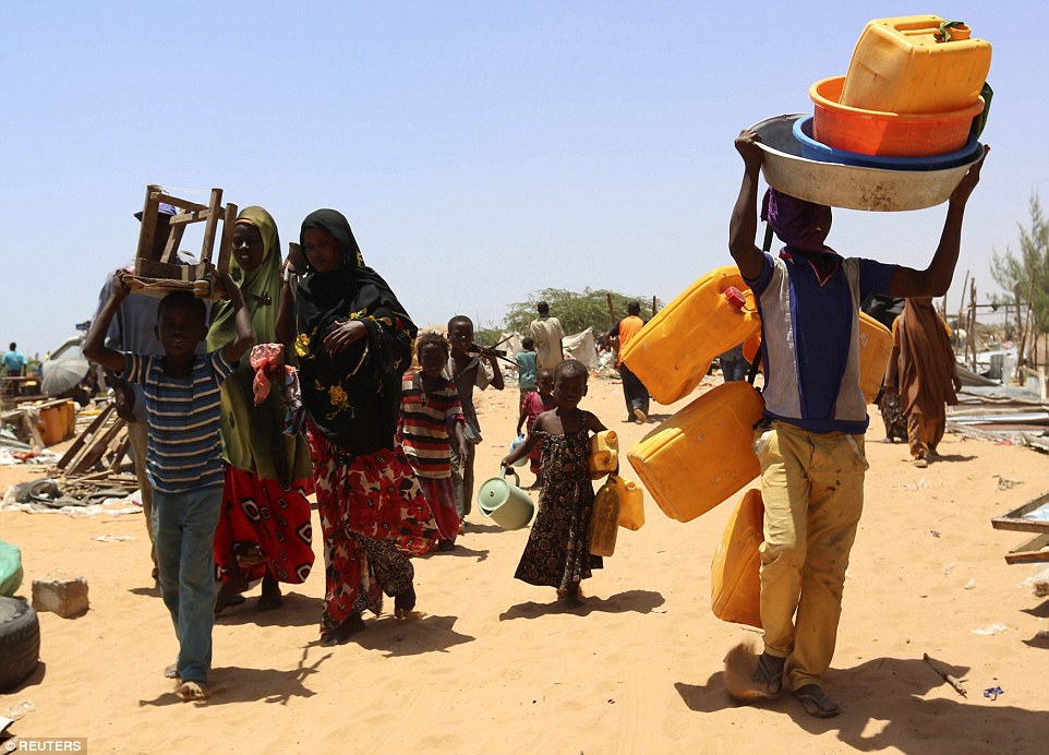 Displaced Somali families carrying personal belongings vacate the camp, which was closed down  by Somali forces, leaving hundreds of families without shelter in capital Mogadishu