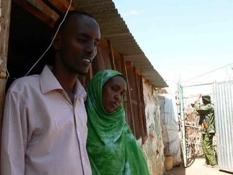 Farah and Hassan Mohamed Abdi, outside their home in Dagahaley refugee camp, Dadaab, while Kenyan security forces hired by the Free Press to prevent a reporter's kidnapping guard the entrance to their home.