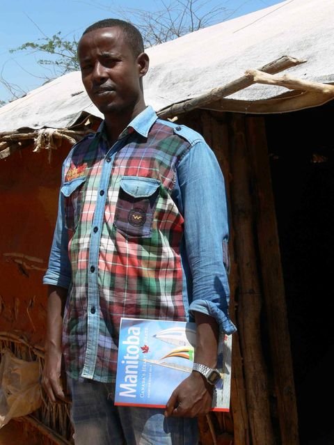 Abdirashid Abukar Mohamud, in the Ifo refugee camp, holds a Travel Manitoba summer guide. He hopes to live and work as an electrician in Winnipeg one day.His Winnipeg uncle Abdi Bashir Ismail who got out of Dadaab in 2003 and is sponsoring his nephew to come to Winnipeg.