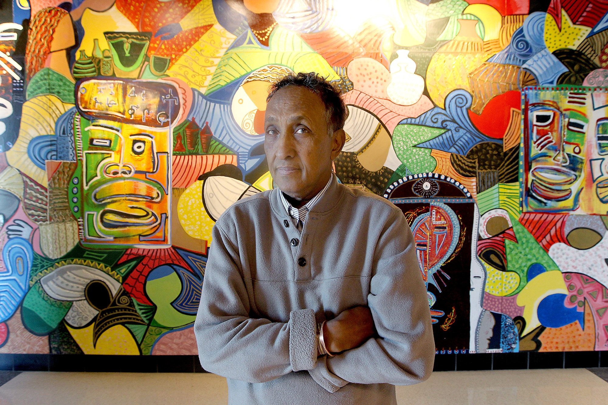 Abdulasis, also known as Aziz, stood in front of a wall-size mural at the Midtown Global Market.
