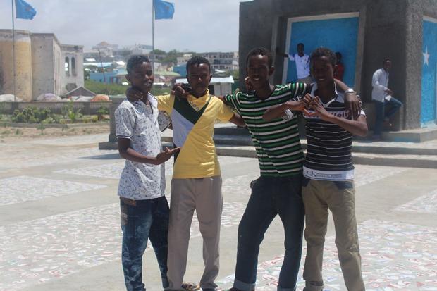 Boys posing for a picture near a Mogadishu monument.