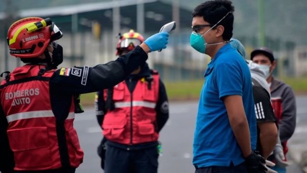 Firemen with thermometers patrol the streets in Quito, testing people for fever