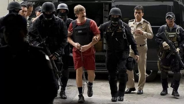 Victor oo gacmaha iyo lugaha ka xiran oo ay garbaha wadaan boolisku