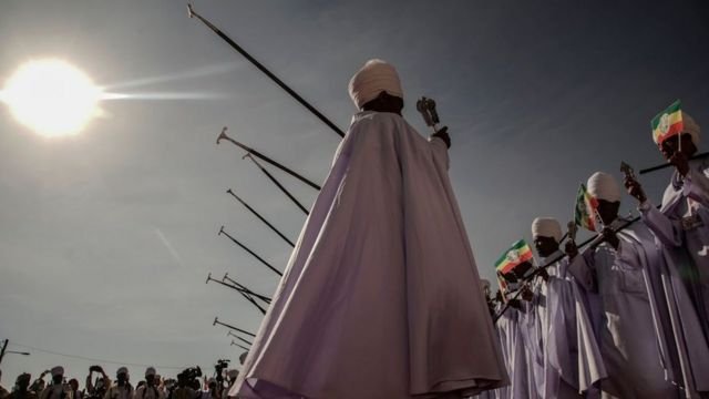 Ethiopian Orthodox High Priests holding Ethiopian Imperial flag perform songs during the celebration of Ethiopian Epiphany in Addis Ababa, Ethiopia, on January 19, 2021. - Timkat is the Ethiopian Orthodox Christian festival which celebrates the baptism of Jesus in the Jordan river.