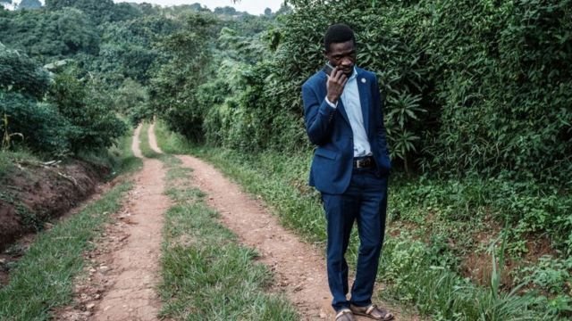 Presidential candidate Robert Kyagulanyi, also known as Bobi Wine, talks on the phone after talking to members of the media at one of his the gates of his home in Magere, Uganda, on January 15, 2021.