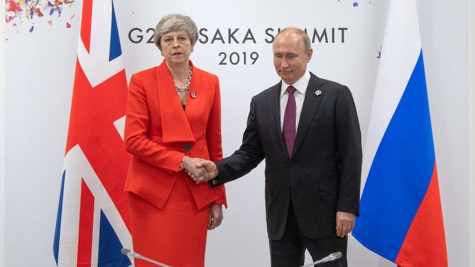 Theresa May iyo Vladimir Putin oo is gacan qaadaya