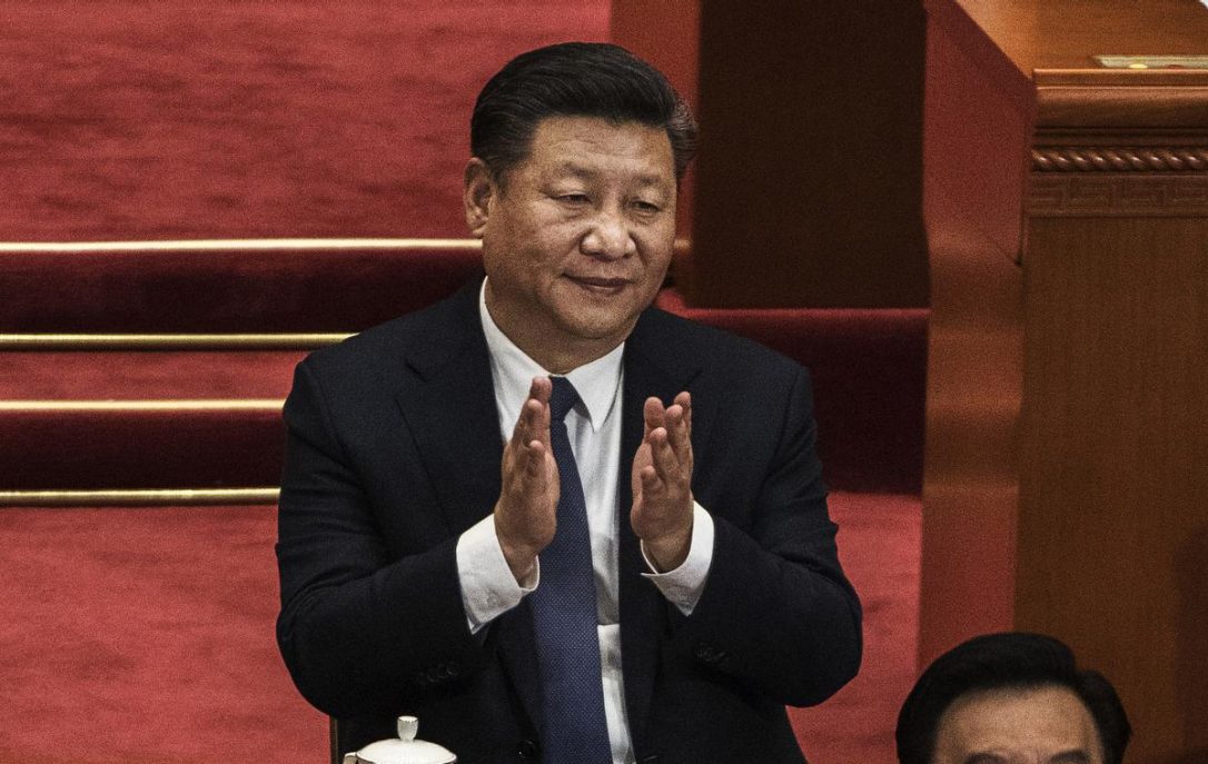 China's President Xi Jinping applauds after a vote on an amendment to the constitution during a session of the National People's Congress in Beijing.